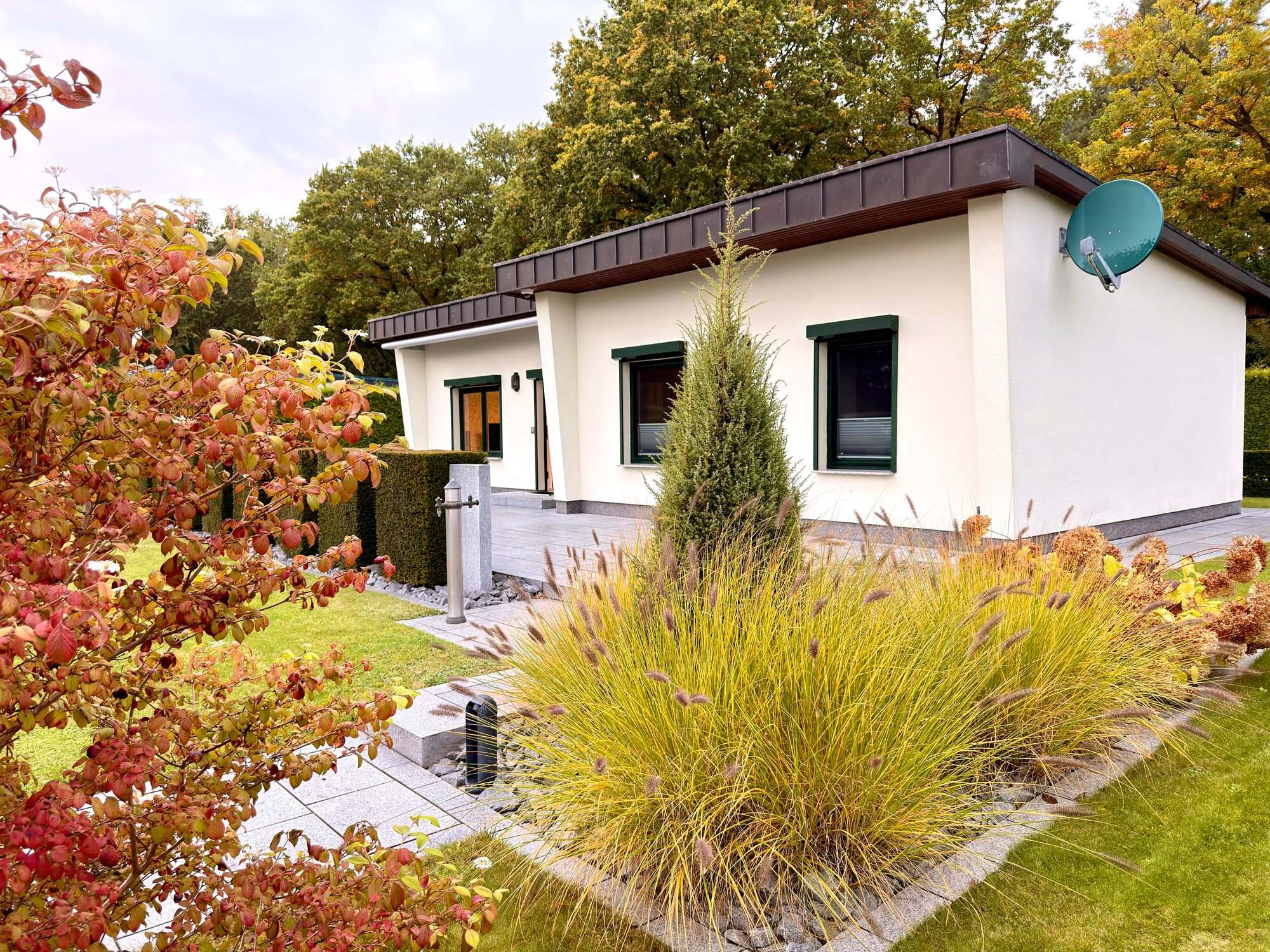 Ferienhaus Kobe mit Herbstgräsern und roten Beerenbüschen