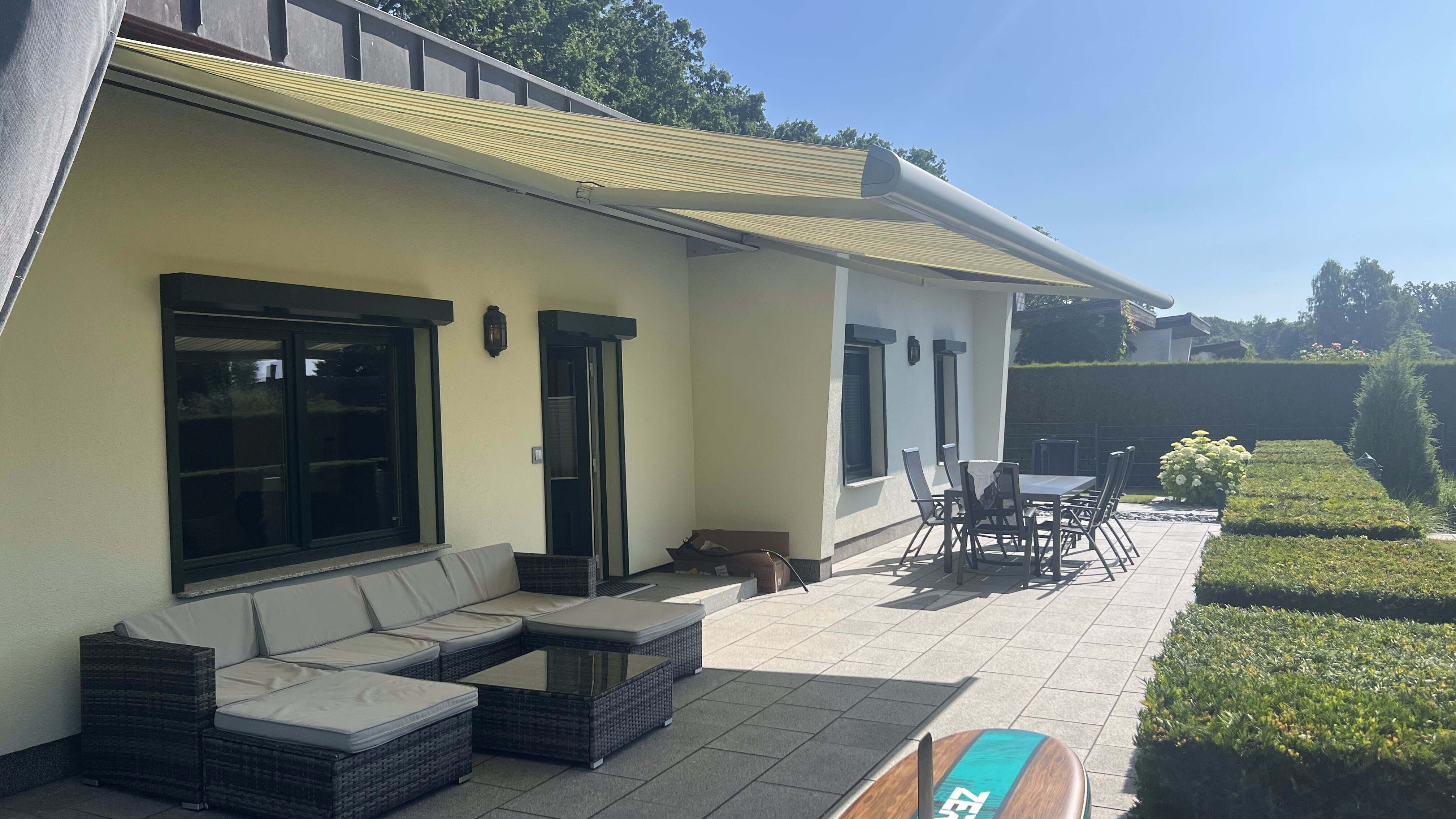 Terrasse mit Lounge-Möbeln und elektrischer Markise am Ferienhaus Kobe